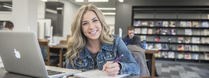 Student studying her class notes on her laptop.